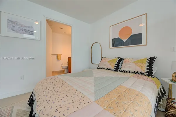 a bedroom with a bed and a painting on the wall