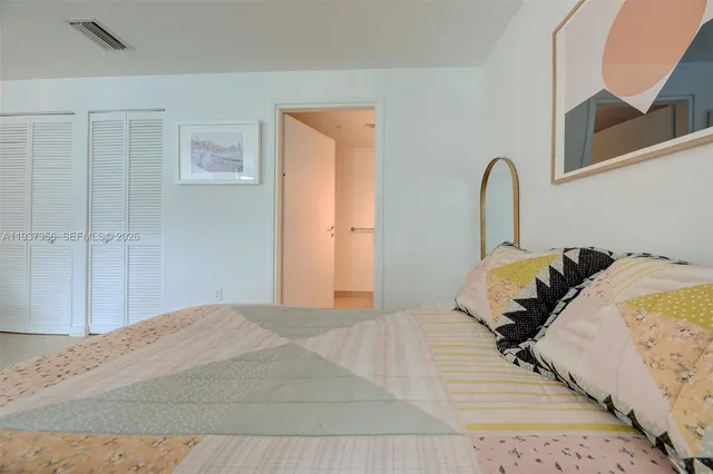 a bedroom with bed and a painting on the wall