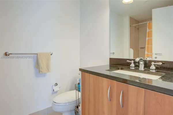 a bathroom with a granite countertop sink and a mirror with toilet
