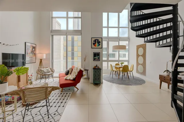 a living room with furniture a flat screen tv and a large window