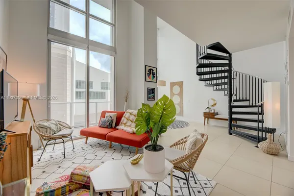 a balcony with chairs and a potted plant
