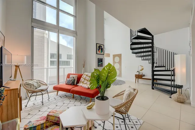 a balcony with chairs and a potted plant