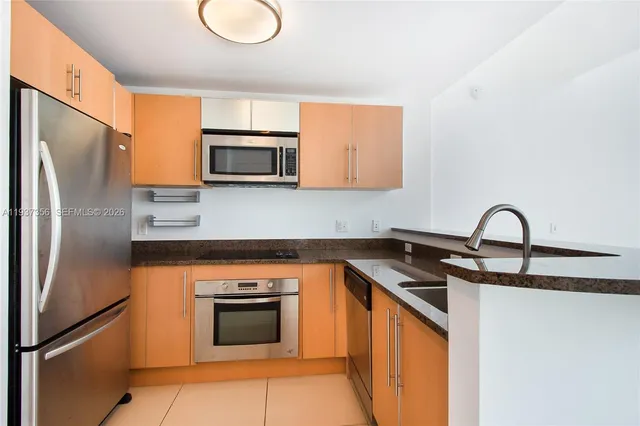 a kitchen with stainless steel appliances granite countertop a stove microwave and a sink
