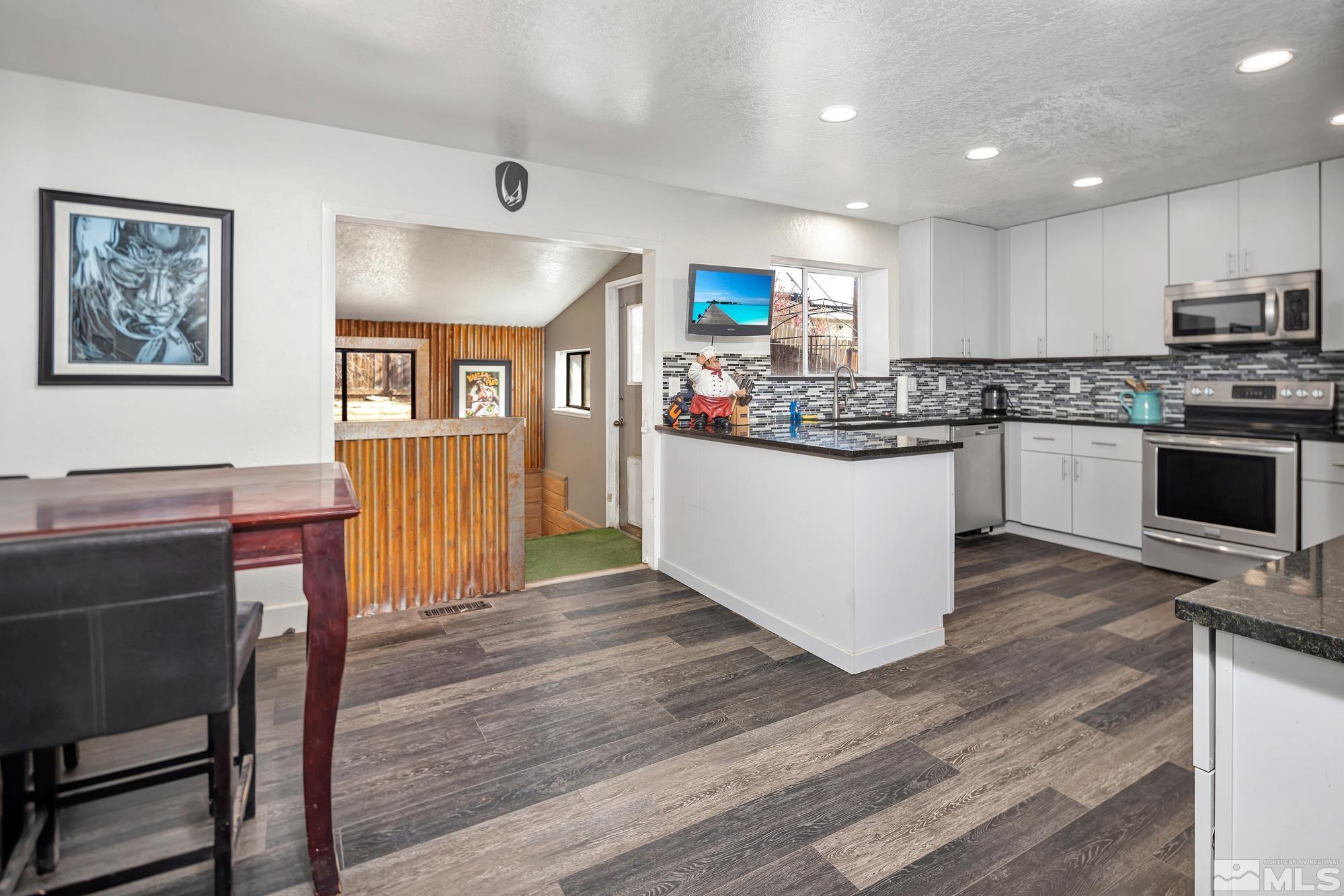 3435 Bowie Road Reno, NV 89503 - Photo 9 of 22 a kitchen with stainless steel appliances granite countertop a stove top oven a sink dishwasher and a refrigerator with wooden floor