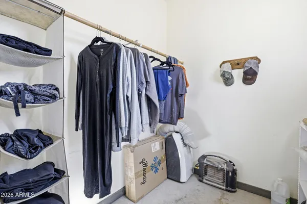 a view of walk in closet with clothes and shoes