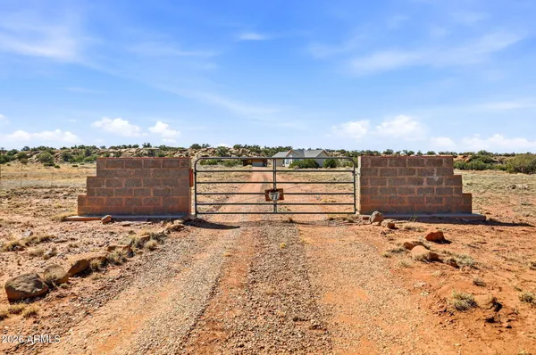 a view of a dry yard with wooden fence