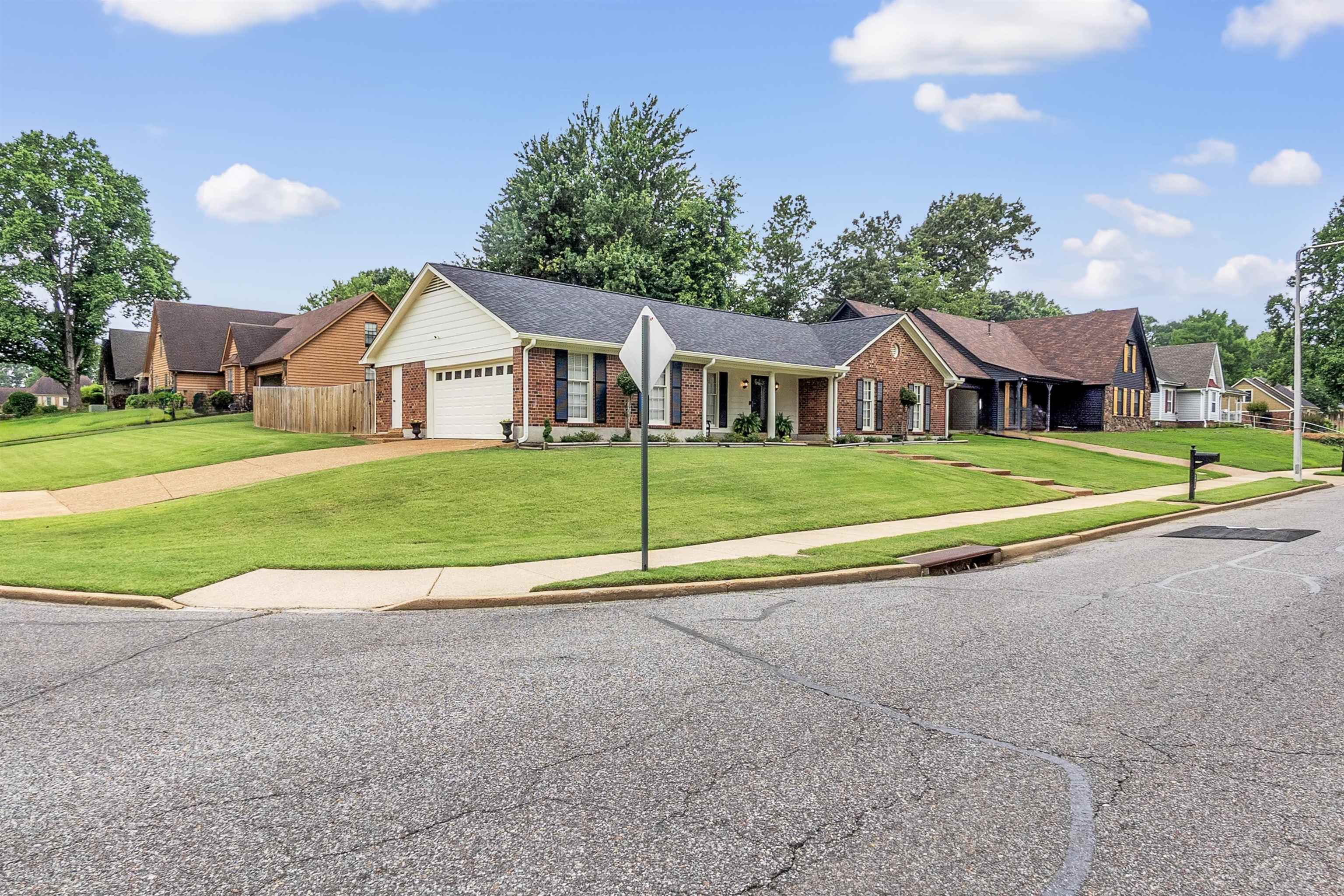 7255 Barnstable Road Memphis, TN 38125 - Photo 3 of 27 Ranch-style house with brick siding, an attached garage, and concrete driveway