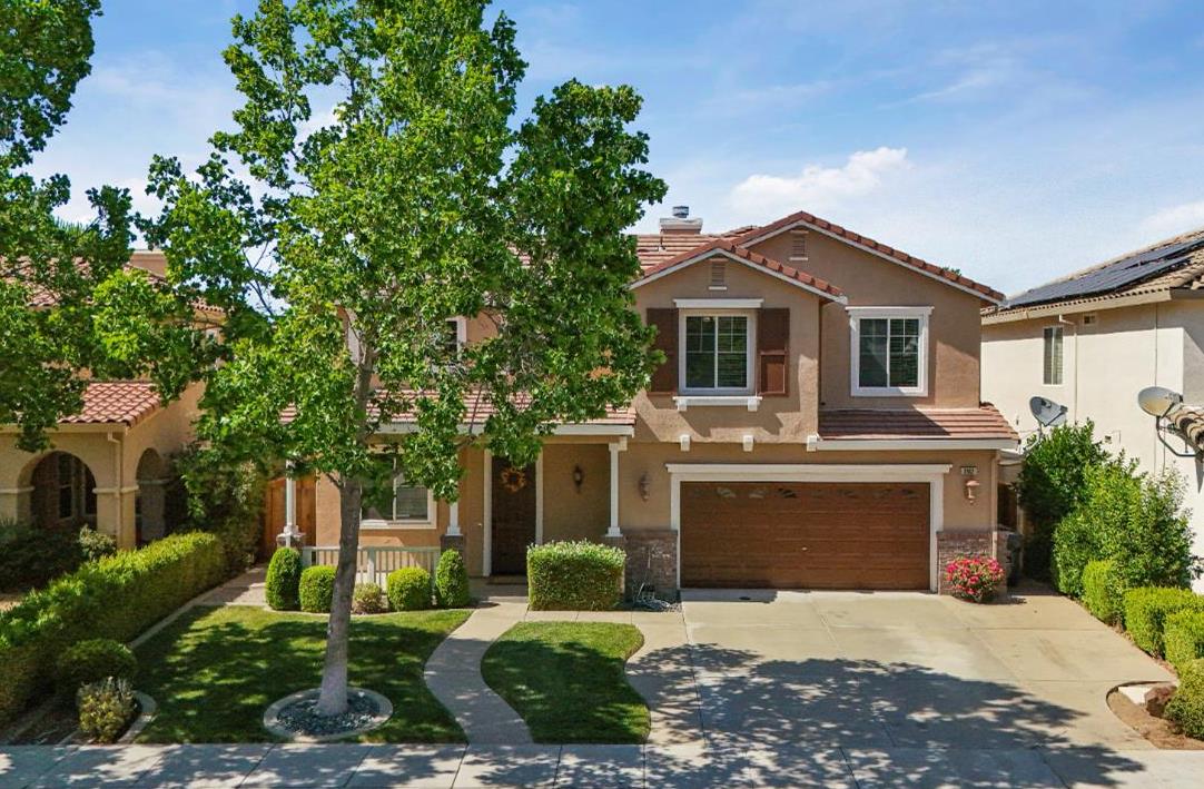 a front view of a house with yard and green space