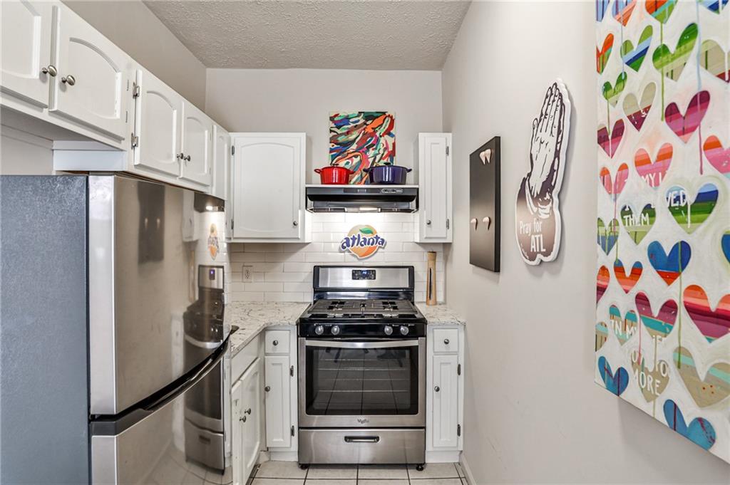 1100 Piedmont Avenue Northeast, Unit 6 Atlanta, GA 30309 - Photo 7 of 16 a kitchen with stainless steel appliances a stove a microwave and cabinets