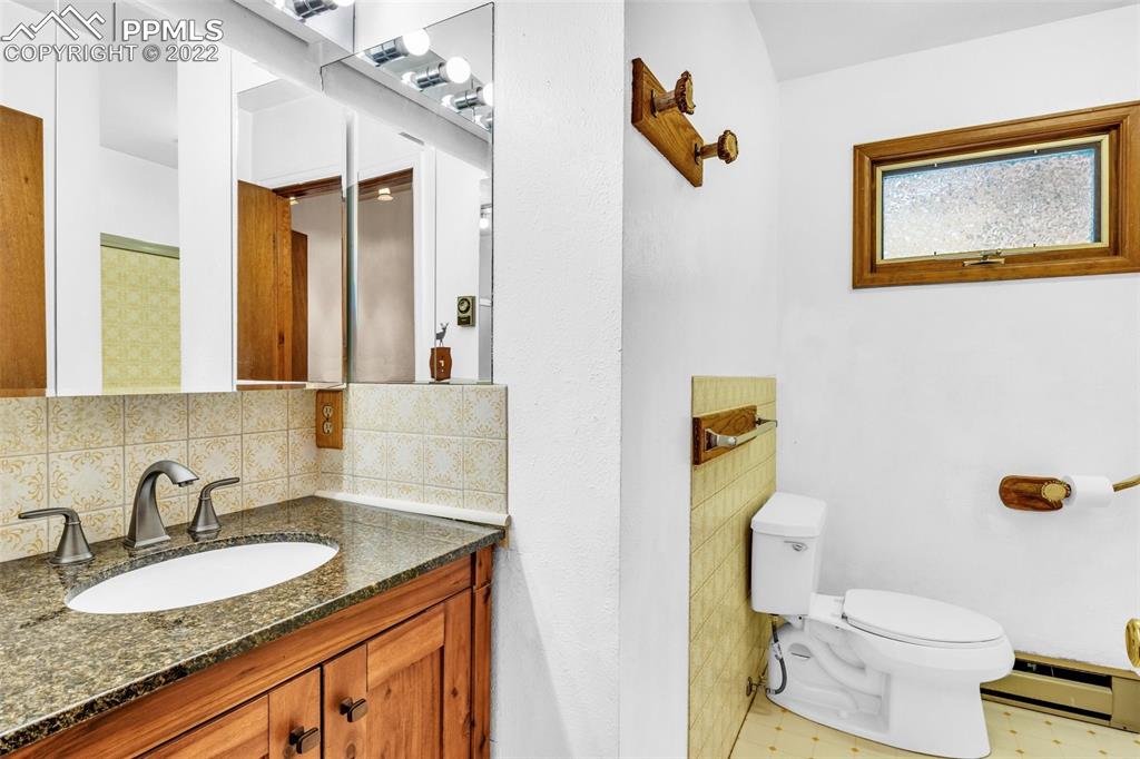1500 Hitchrack Road Bailey, CO 80421 - Photo 18 of 43 a bathroom with a granite countertop sink mirror vanity and toilet