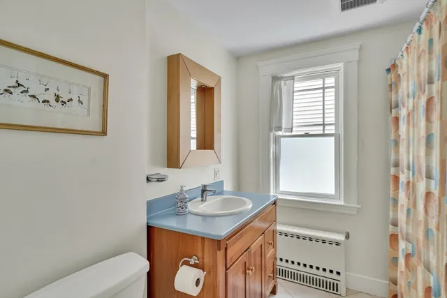 a bathroom with a sink a toilet and a window