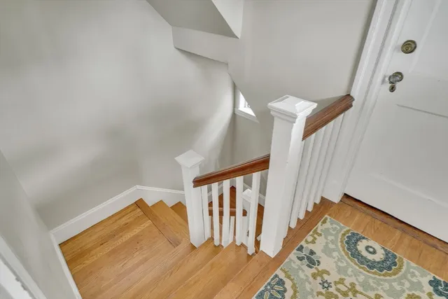 a view of a bedroom with wooden floor and stairs