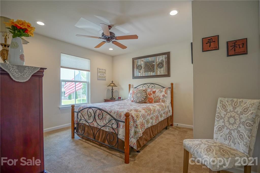 7788 East Berkeley Road, Unit 1106 Denver, NC 28037 - Photo 23 of 48 a bedroom with a bed and a chandelier