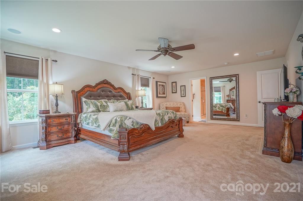 7788 East Berkeley Road, Unit 1106 Denver, NC 28037 - Photo 36 of 48 a bedroom with a bed and a chandelier