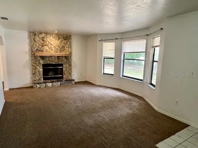 a view of an empty room with a fireplace and a window