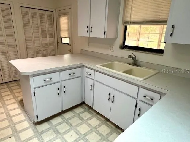 a kitchen with a sink cabinets and window