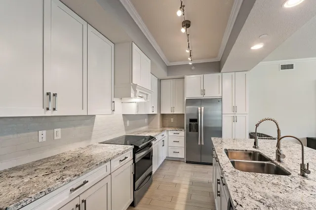 a kitchen with a refrigerator a stove a sink and chairs