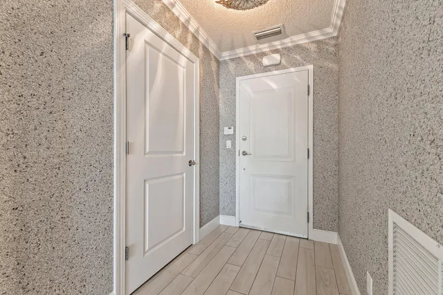 a kitchen with stainless steel appliances granite countertop a stove top oven a sink dishwasher a refrigerator and a dining table with wooden floor