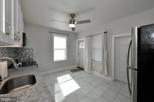 a kitchen with a refrigerator sink and cabinets