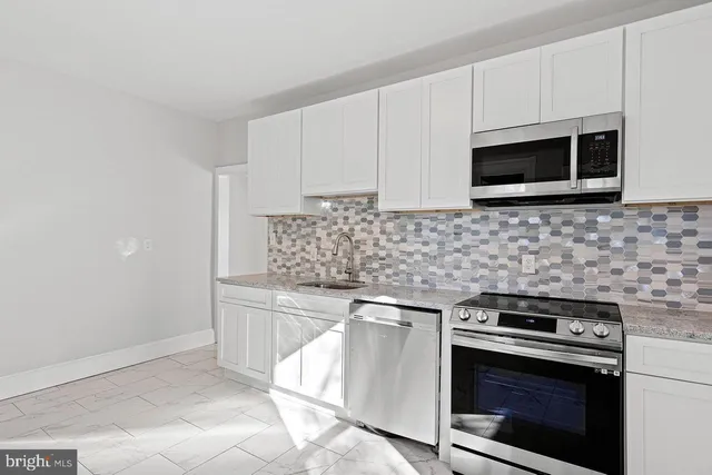 a kitchen with stainless steel appliances a stove microwave and cabinets