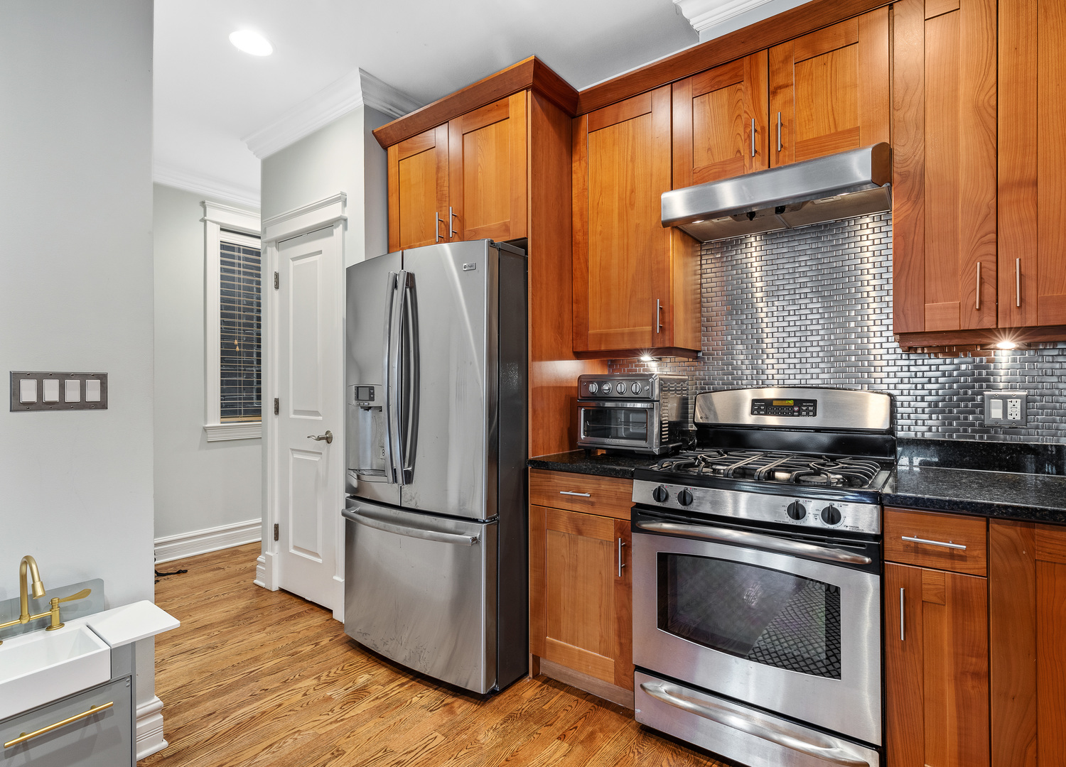1037 West Monroe Street, Unit 3 Chicago, IL 60607 - Photo 9 of 25 a kitchen with granite countertop stainless steel appliances and wooden cabinets