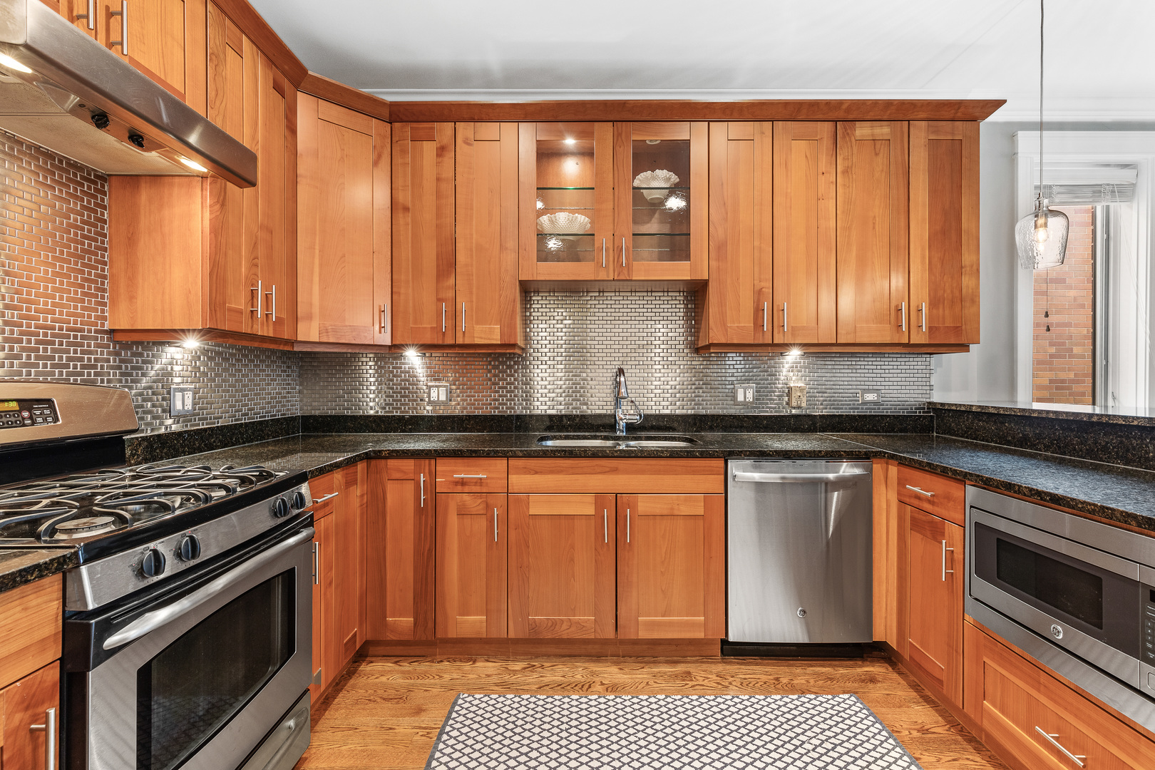 1037 West Monroe Street, Unit 3 Chicago, IL 60607 - Photo 10 of 25 a kitchen with stainless steel appliances granite countertop a stove a sink and a microwave