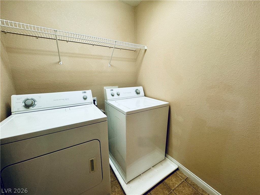 8617 Palomino Ranch Street Las Vegas, NV 89131 - Photo 26 of 27 Functional laundry space featuring convenient shelving above the included washer and dryer.