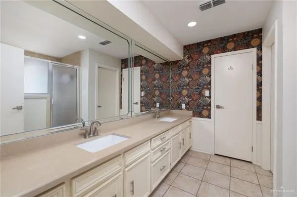 a bathroom with a double vanity sink and mirror
