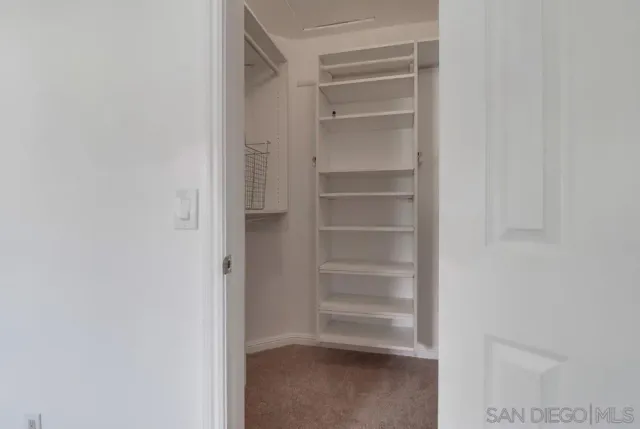 a view of walk in closet with empty racks
