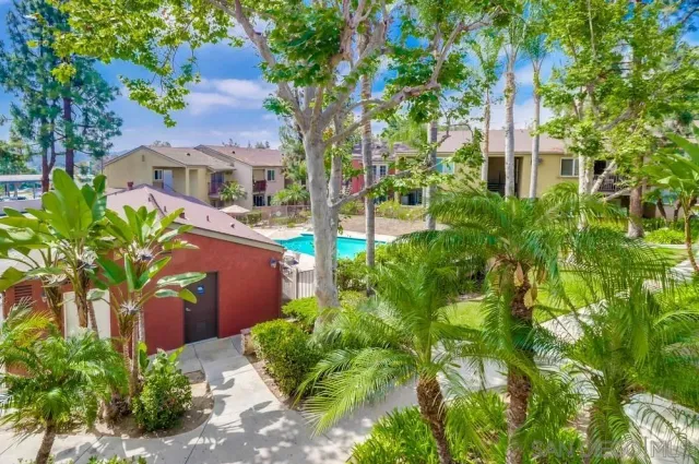 a front view of a multi story residential apartment building with yard and retail shops