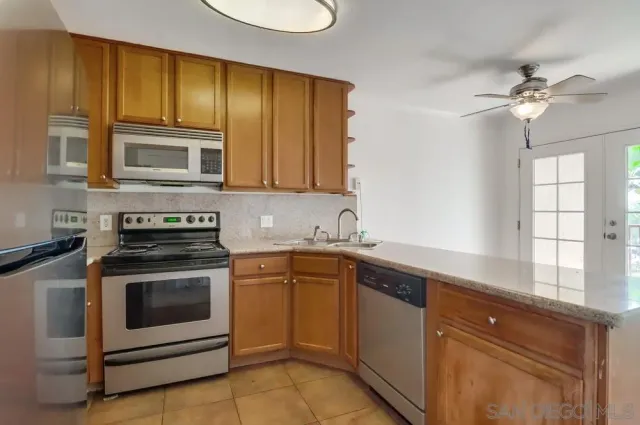 a kitchen with cabinets stainless steel appliances and a window