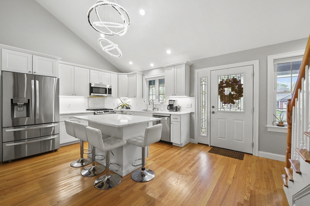 17 Turtle Lane, Unit 17 Sterling, MA 01564 - Photo 5 of 26 a kitchen with stainless steel appliances granite countertop a refrigerator a stove a sink dishwasher and white countertops with wooden floor