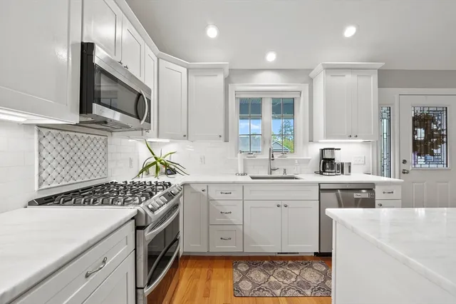a kitchen with stainless steel appliances a stove a sink and a microwave