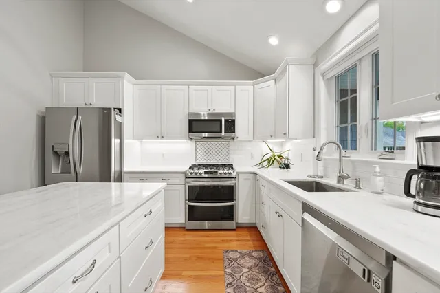 a kitchen with white cabinets and stainless steel appliances