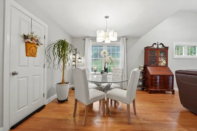 a view of a dining room with furniture a chandelier and wooden floor