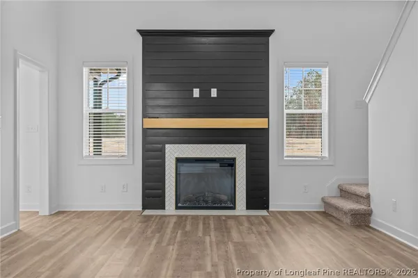 a view of an empty room with a fireplace and a window