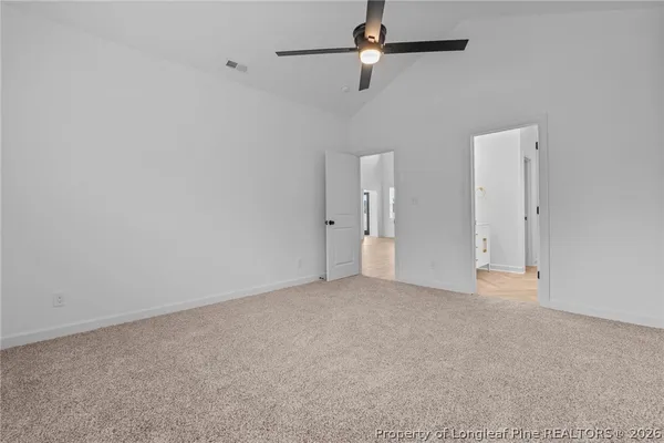 an empty room with a ceiling fan and window