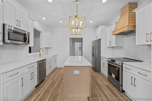 a kitchen with stainless steel appliances a stove a sink and a refrigerator