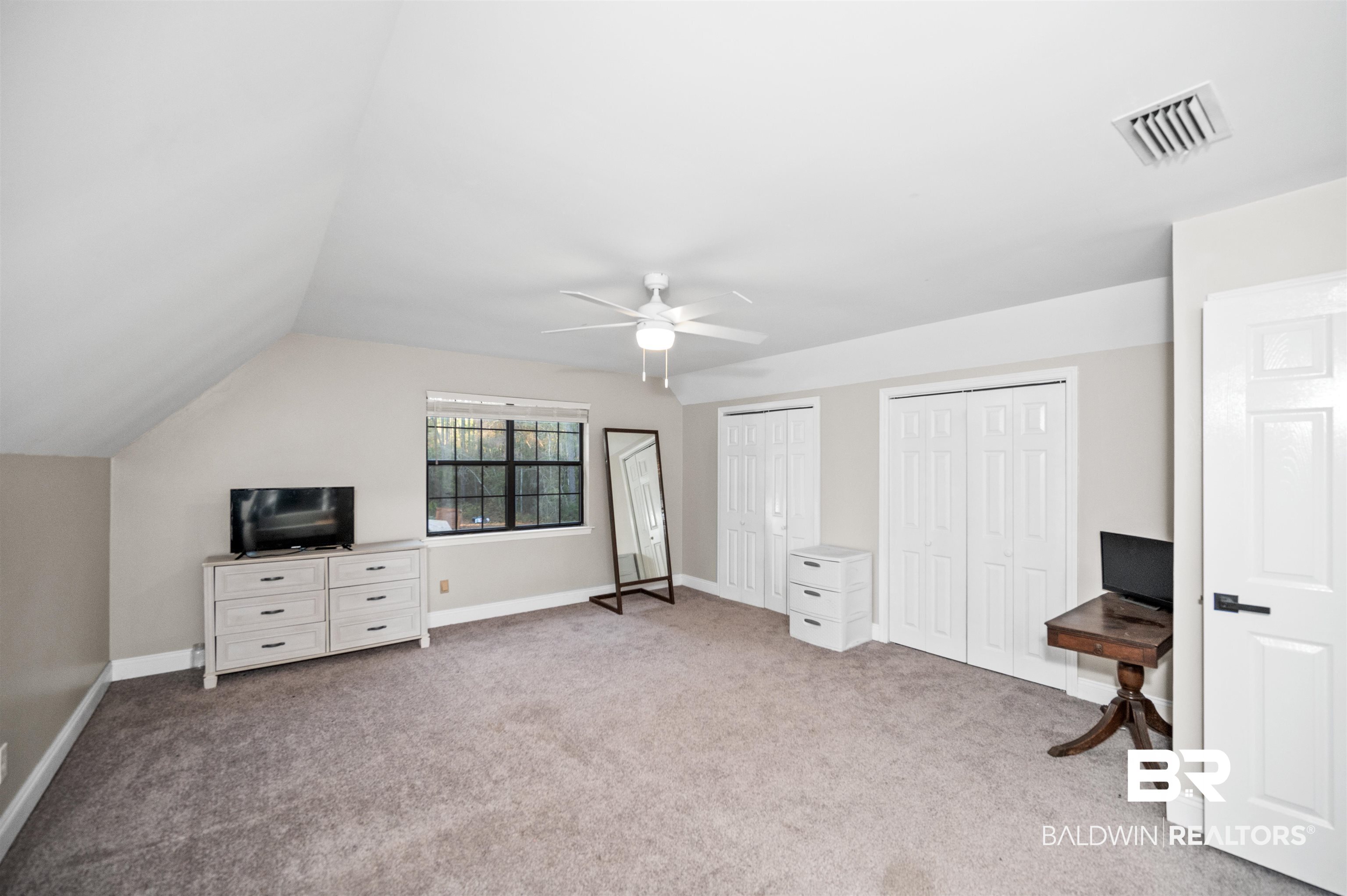 19274 Rada Road Silverhill, AL 36576 - Photo 11 of 18 Bedroom featuring ceiling fan, light colored carpet, lofted ceiling, and two closets