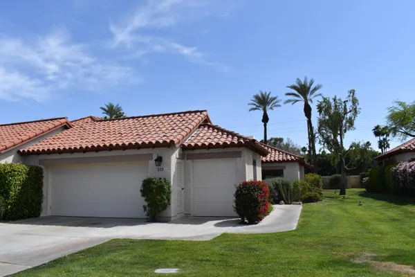 a front view of a house with a garden and plants
