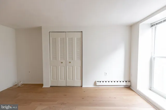 a view of a room with wooden floor and a bathroom
