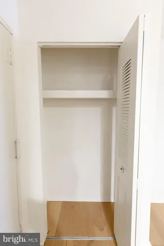 a view of an empty room with wooden floor and stairs