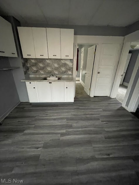 10210 Reno Avenue Cleveland, OH 44105 - Photo 9 of 26 Kitchen featuring white cabinets, dark hardwood / wood-style flooring, sink, and backsplash