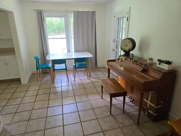 a living room with a table chairs and a window