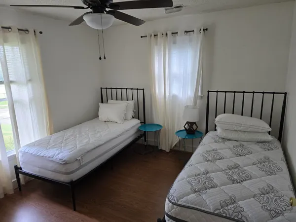 a bedroom with bed and wooden floor