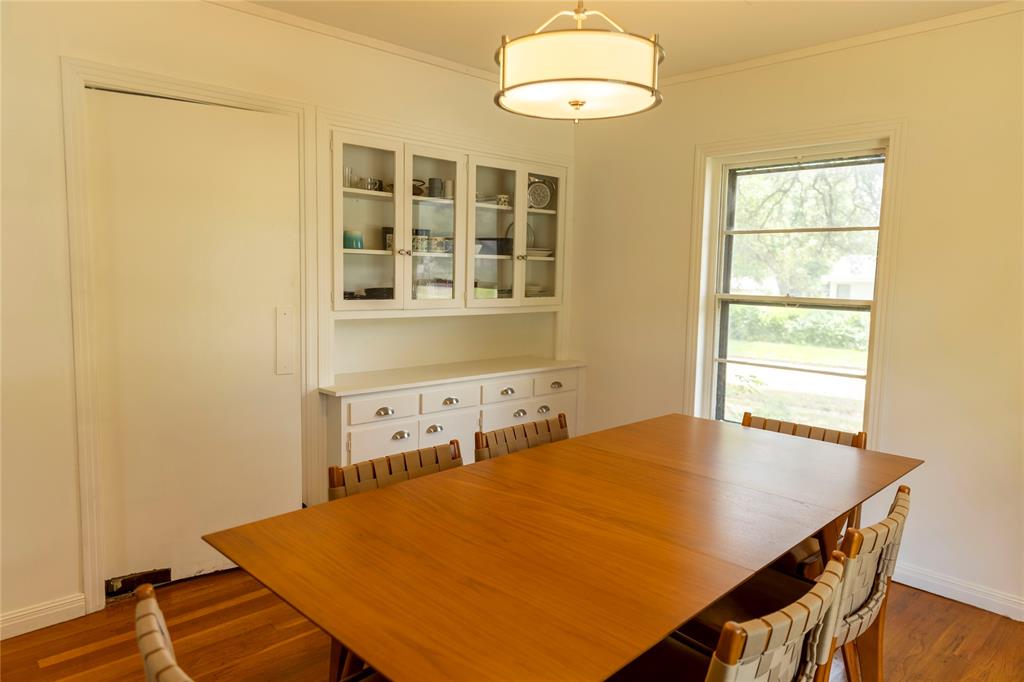 3228 Colcord Avenue Waco, TX 76707 - Photo 10 of 29 Dining space with wood-finish flooring, a built-in china cabinet with glass-front uppers, and a single window