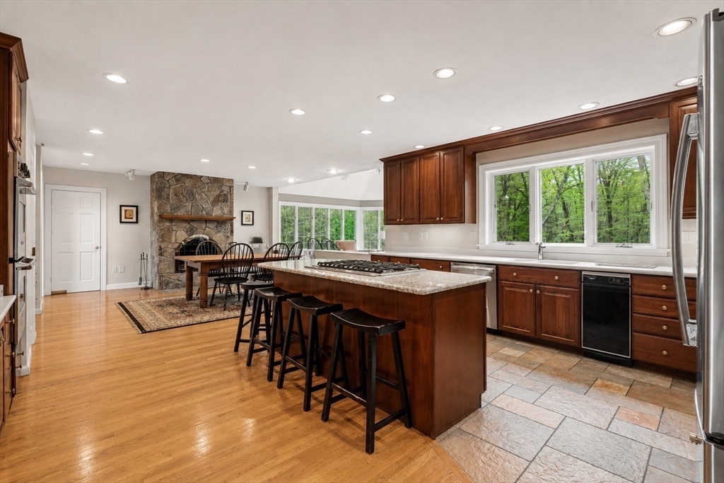 37 Old Planters Road Beverly, MA 01915 - Photo 10 of 42 a kitchen with stainless steel appliances granite countertop wooden cabinets a sink a stove a dining table and chairs