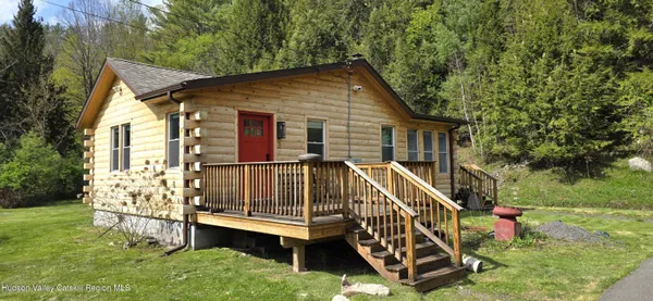 a view of house with a yard and deck area