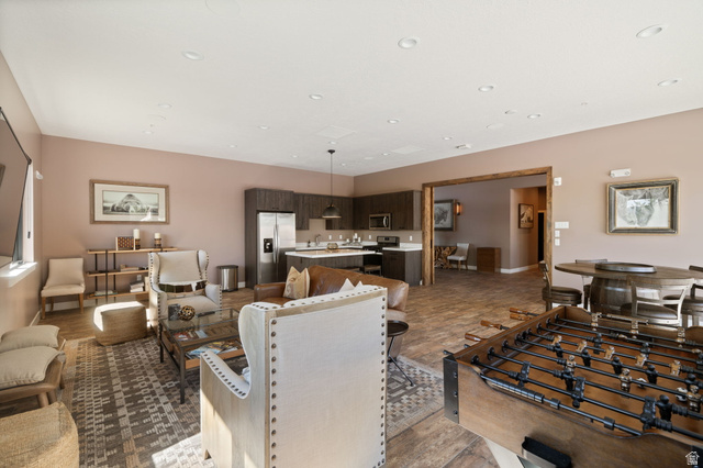 910 Wasatch Drive Kamas, UT 84036 - Photo 27 of 36 Expansive open-concept living area featuring wood-finish flooring, recessed lighting, and a modern kitchen with dark cabinetry, stainless steel appliances, and a central island