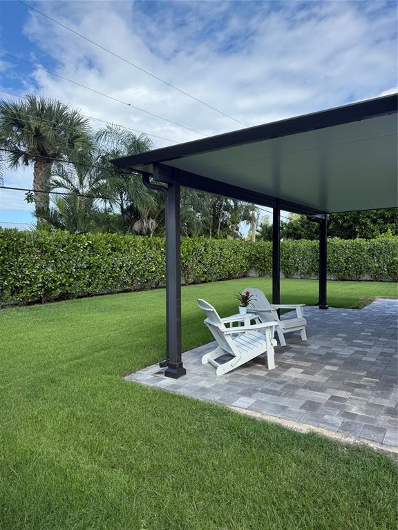 1269 Northwest 4th Street Boca Raton, FL 33486 - Photo 28 of 35 a view of a patio with table and chairs under an umbrella